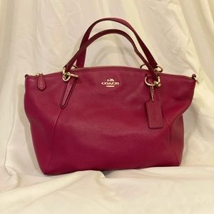 Cute, purplish pink colored Coach Purse with gold hardware.